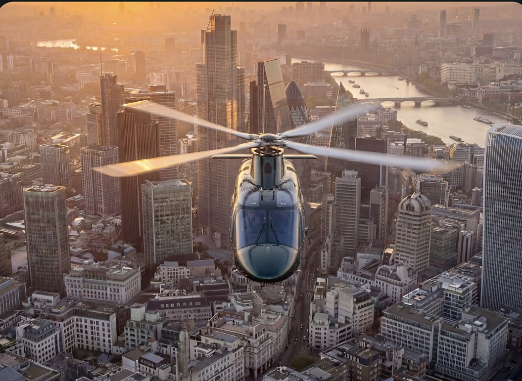 Helicopter flying over a city beside a river