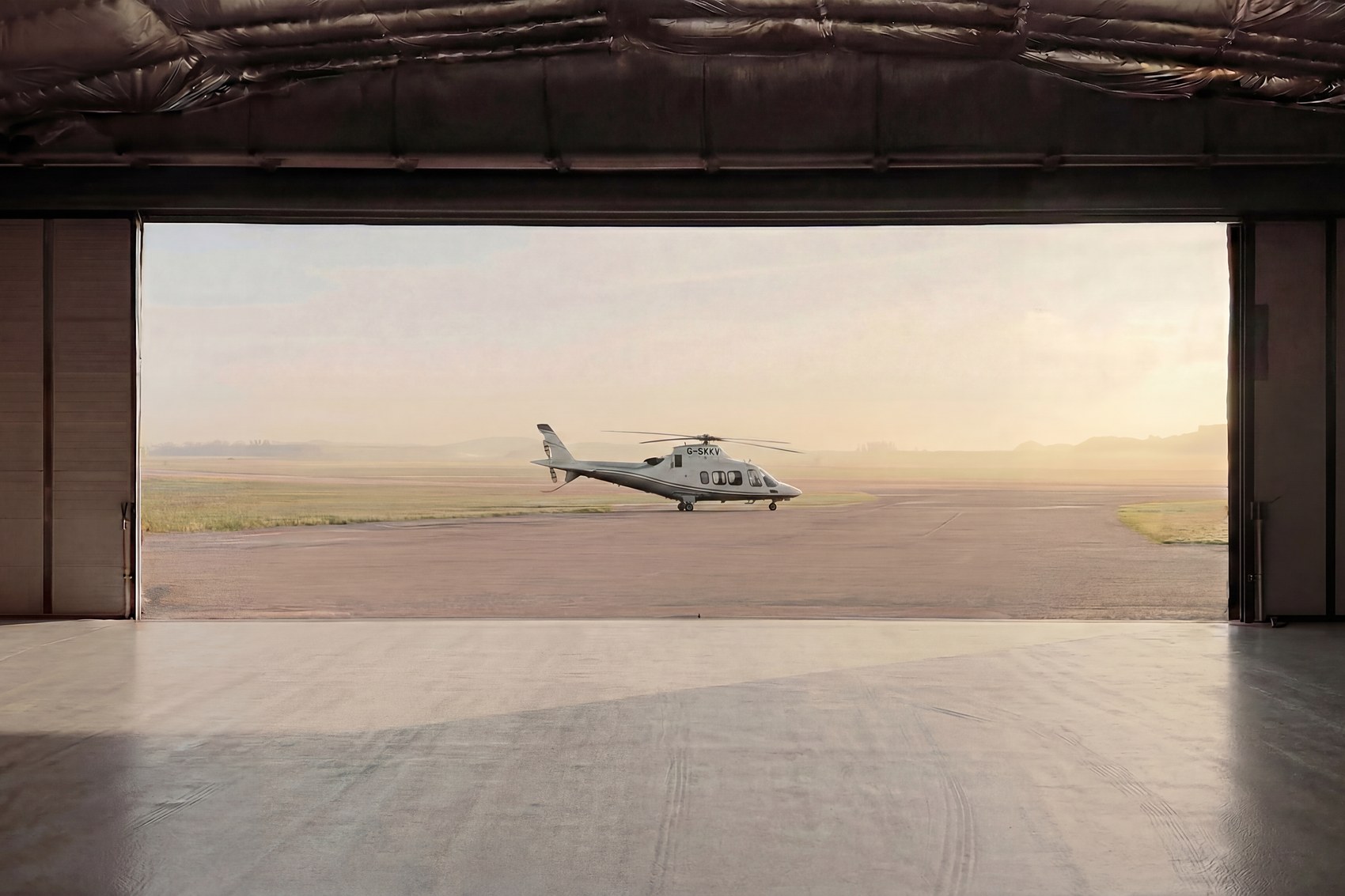 Helicopter inside a hangar with the doors open