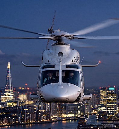 Helicopter hovering over the lit London skyline at dusk
