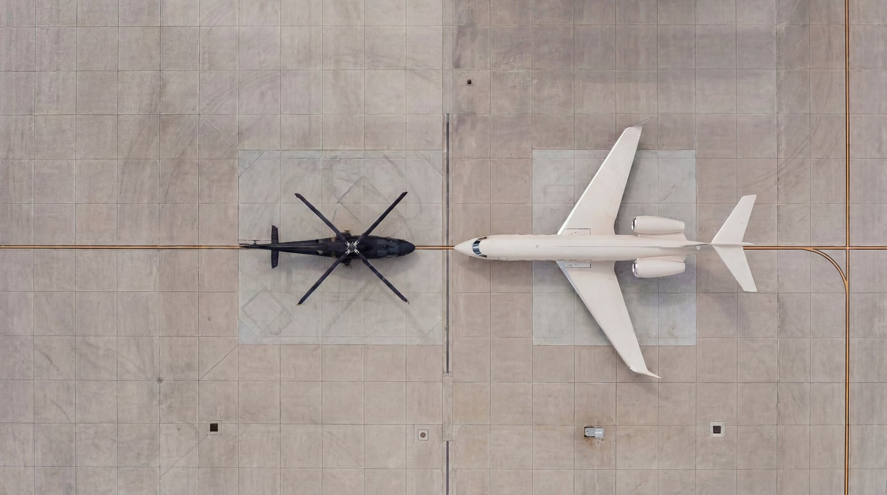 A helicopter and a private jet seen from above on an apron