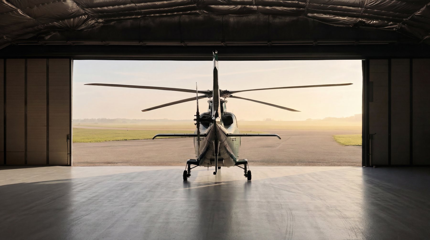 Helicopter inside a hangar with the doors open